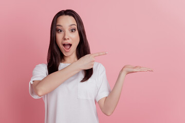 Photo of young excited girl point finger product offer select sale advertise isolated over pink color background