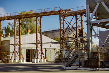 Territory of factory or production plant with industrial buildings, ladders and equipment under...