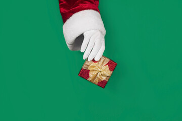 Santa Claus hand holding a red gift box. Concept of Christmas. Sale. Black Friday.