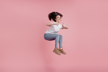 Fototapeta na wymiar Full size photo of young cheerful girl jump up fly show thumbs-up like advertise recommend isolated over pink color background