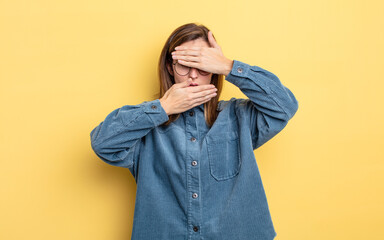 young pretty girl covering face with both hands saying no to the camera! refusing pictures or...