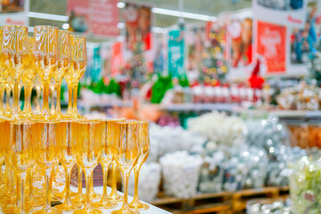 Yellow Glass goblets on a blurry Christmas background with festive goods.