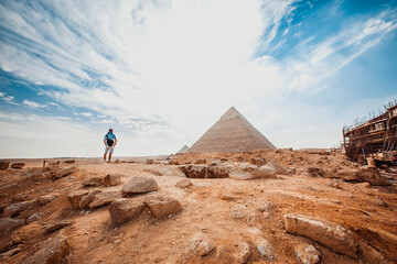 A tourist man stands with his back to the camera and looks at the pyramids. Meditation near the pyramids in Cairo, Egypt