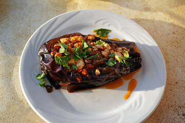 baked eggplant with feta cheese and herbs on the table in greek tavern, typical greek cuisine