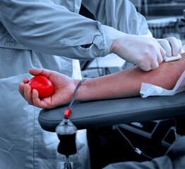 Blood donor at donation with a bouncy ball holding in hand.