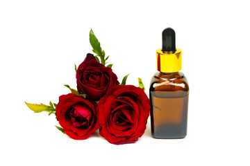 Obraz na płótnie Canvas Rose oil in glass bottle with red rose flower isolated on white background. Essential oil product concept.