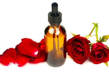 Rose oil in glass bottle with red rose flower isolated on white background. Essential oil product concept.