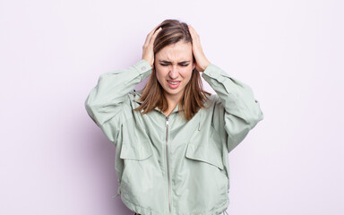young pretty girl feeling stressed and frustrated, raising hands to head, feeling tired, unhappy...