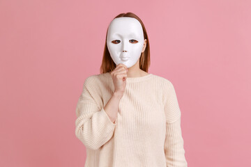 Portrait of unknown anonymous woman covering her face with white mask, hiding her real personality,...