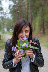 Falling in love, dating with a loved one. Happy beautiful young girl with a bouquet of wildflowers, close-up portrait