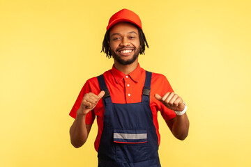Smiling happy bearded courier or builder wearing overalls, looking at camera with proud expression,...