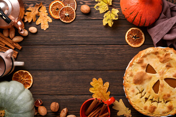 Halloween food. Homemade pumpkin pie or tart with a scary face for Halloween on a wooden table. Copy space. Halloween food concept.