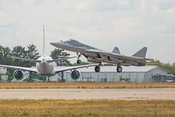 Fototapeta na wymiar Military jet at take off in the background a passenger plane.