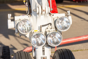 Close up aircraft landing lights on the front landing gear near.