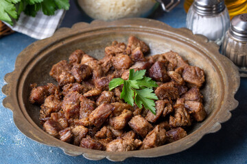 Muslims Traditional Sacrifice holiday food lamb, Turkish roasted meat in copper pot on table top. Turkish Kavurma.