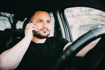 the man behind the wheel is talking on the phone