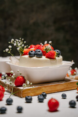 Beautiful white cake decorated with strawberries, blueberries and flowers