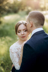 the groom and the bride are walking in the forest near a narrow river