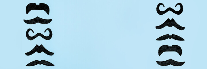 Creative flatlay overhead top view retro black props moustaches blue background copy space. Men...