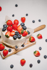 Confectionery on white background, strawberry blueberry cake