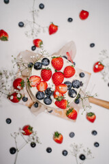 Confectionery on white background, strawberry blueberry cake