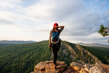 Traveler on the background of the mountain, rear view. A woman is traveling in Bashkiria, Russia....