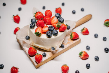 small strawberry bento cake. garnished with strawberries and blueberries