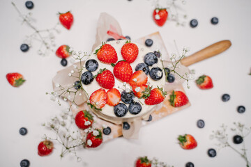 Naklejka na ściany i meble Confectionery on white background, strawberry blueberry cake