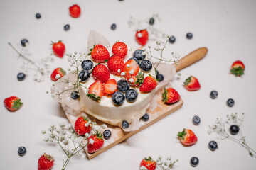 Beautiful strawberry cake decorated with blueberries on a white background