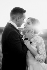 the groom and the bride walk along the wheat green field