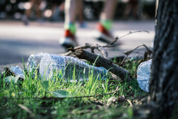 Naklejka premium Botellas tiradas en el suelo sin reciclar después de una carrera de running