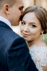 the bride and groom are walking in a pine forest