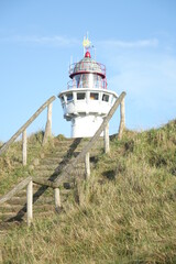 Fototapeta na wymiar J. C. J. van Speijk Lighthouse seen from the beach on a cold and sunny winter day, Egmond aan Zee, North Holland, Netherlands 