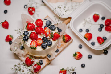 Beautiful strawberry cake decorated with blueberries on a white background