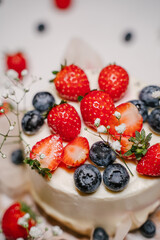 Beautiful strawberry cake decorated with blueberries on a white background
