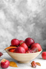 Beautiful fresh red apples with autumn leaves in a wooden vase
