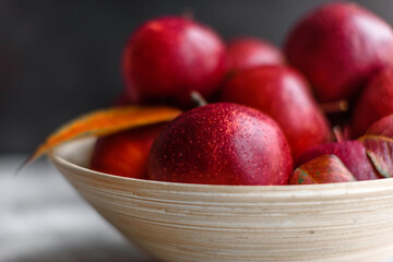 Beautiful fresh red apples with autumn leaves in a wooden vase