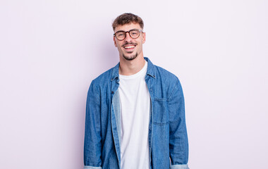 young handsome man with a big, friendly, carefree smile, looking positive, relaxed and happy,...