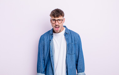 young handsome man looking shocked, angry, annoyed or disappointed, open mouthed and furious