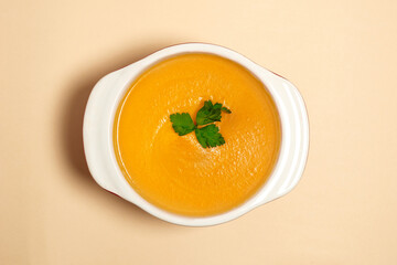 ready-made pumpkin soup cream in a saucepan top view. Flat lay of utensils for cooking on beige background. healthy food