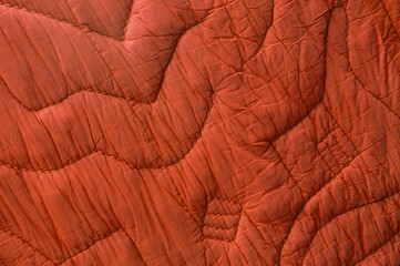 red large bedspread. orange unusual texture. magenta rippled background. purple embossed surface