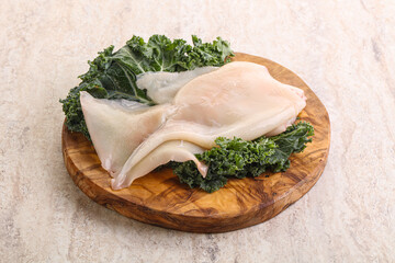 Raw squid over wooden board