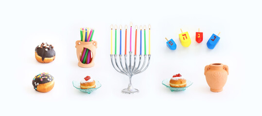 Religion image of jewish holiday Hanukkah background with menorah (traditional candelabra), doughnut and candles over white background