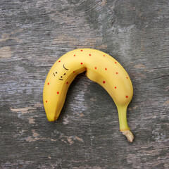 Banana on the old wooden background. The concept of safe sex. Flat lay. Top view.