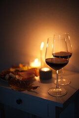 Candlelight date - two glasses of red wine with candles on the table