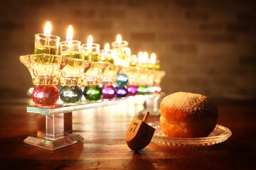 image of jewish holiday Hanukkah background with crystal menorah (traditional candelabra) and oil candles