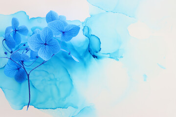 Creative image of blue Hydrangea flowers on artistic ink background. Top view with copy space