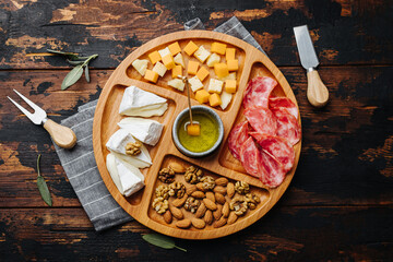 Wine snacks. Assorted cheese on a wooden board.