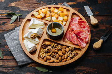 Wine snacks. Assorted cheese on a wooden board.