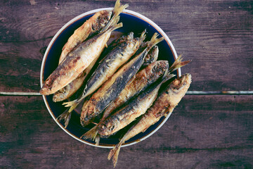 A plate of fried horse mackerel standing on a wooden table